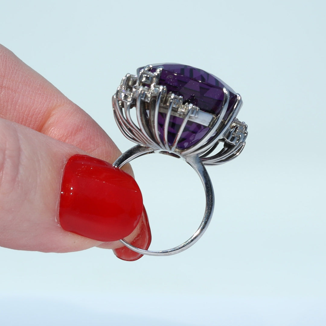 Oval faceted amethyst surrounded by brilliant cut diamonds