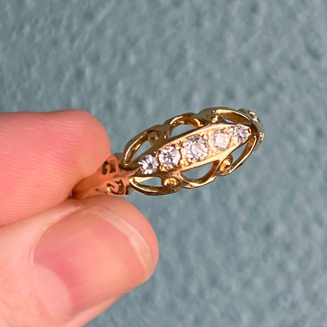 Close up of antique Edwardian five stone diamond ring in yellow gold