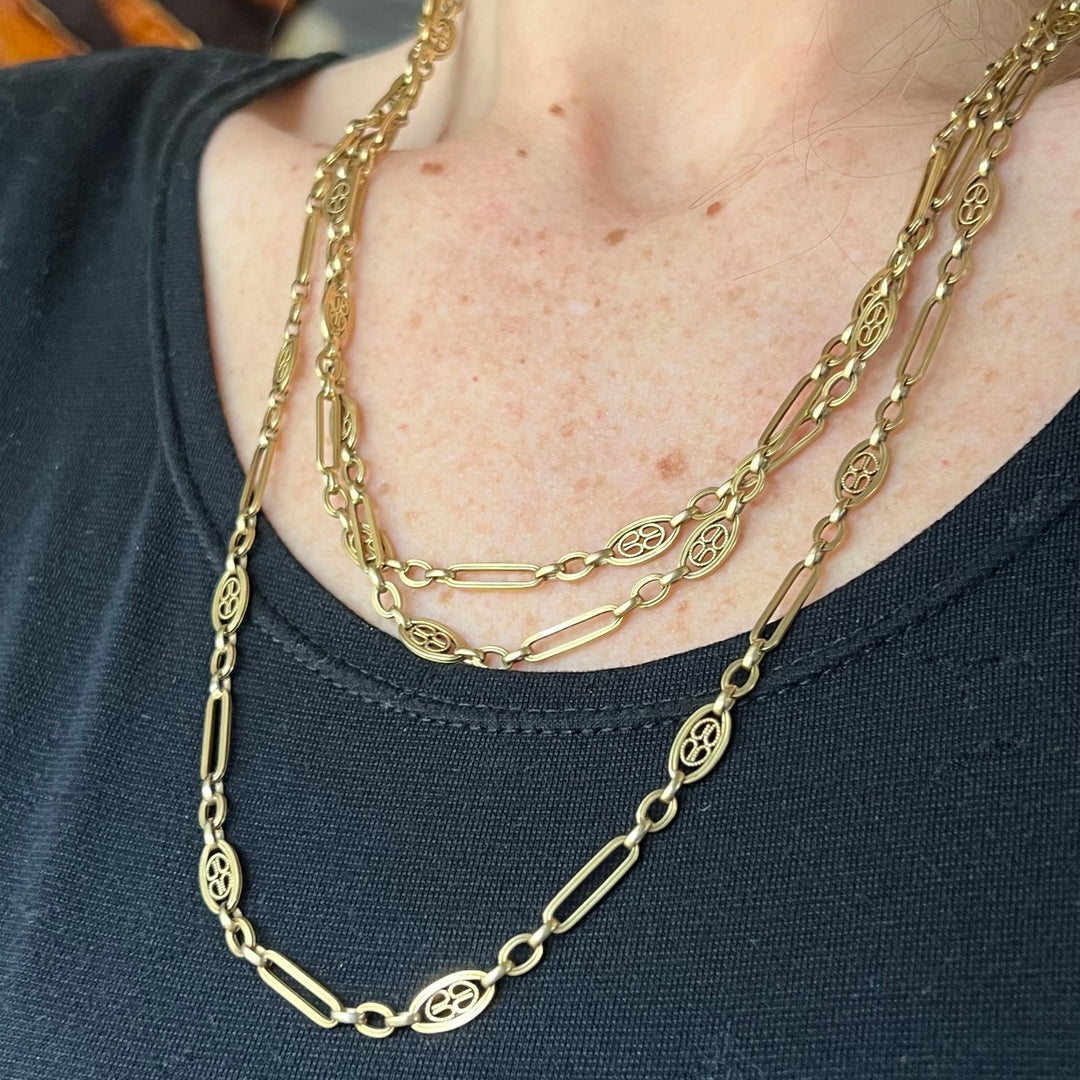 Long gold chain worn doubled around neck antique style