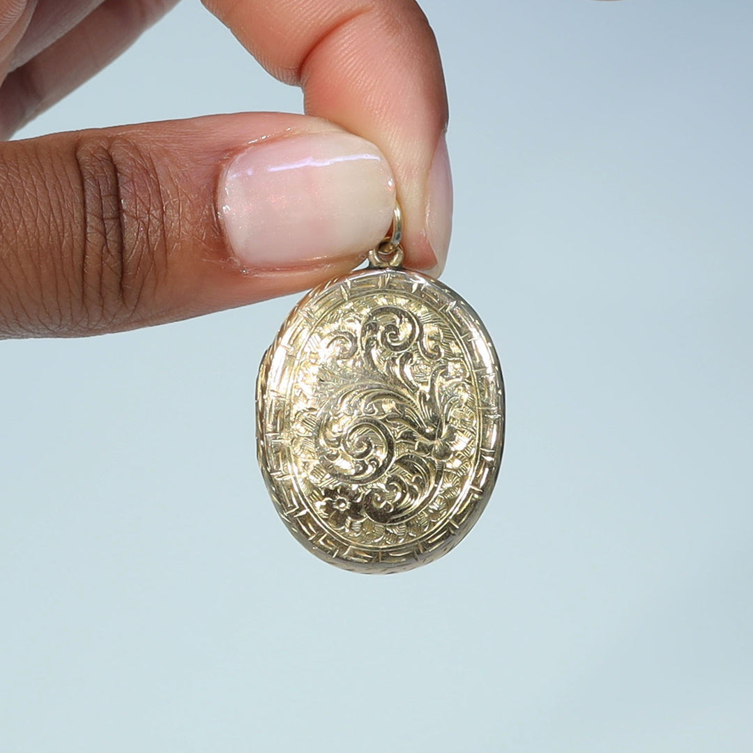 Antique oval gold locket decorated with leaves and scrolls