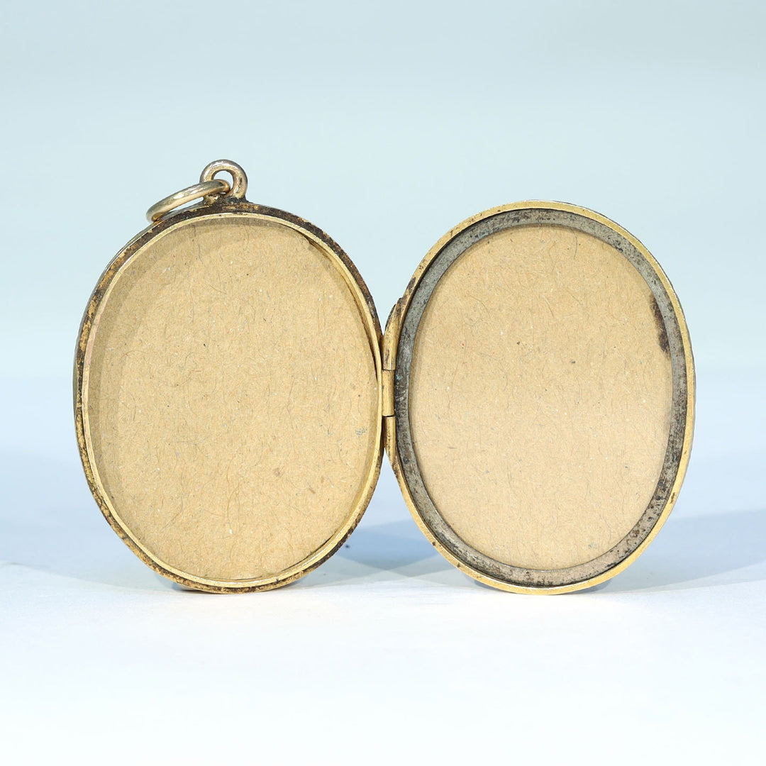 Antique gold photo locket with two interior compartments