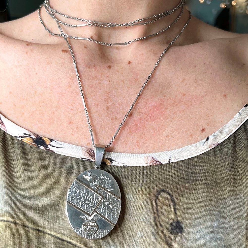 Antique silver bird locket with floral motifs