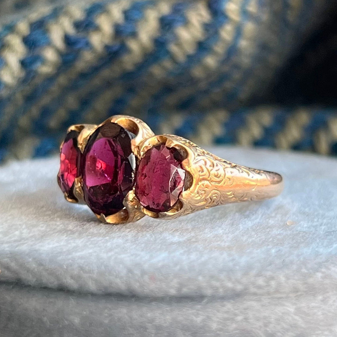 Close view of deep red garnet trilogy ring