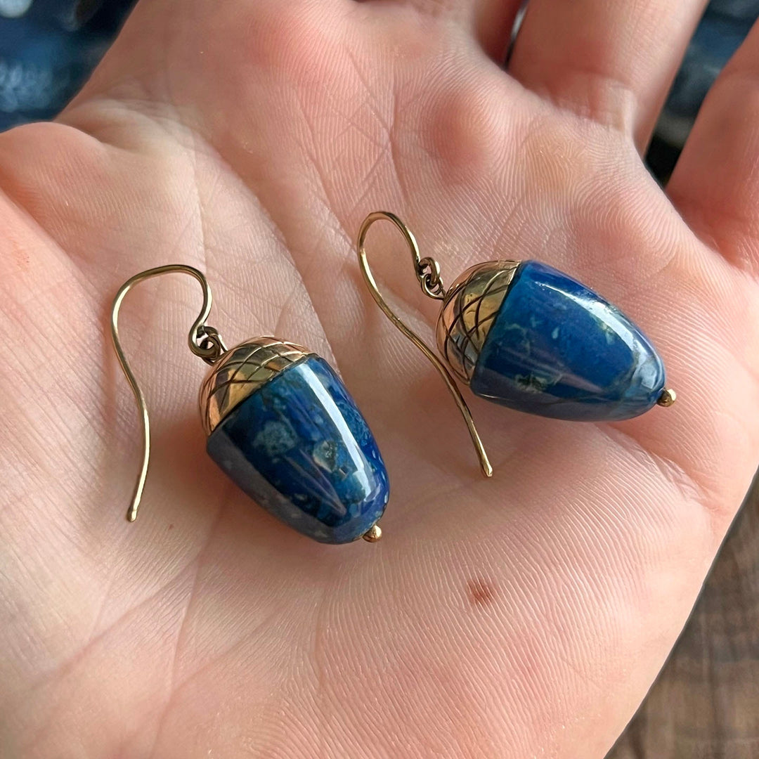 Detail of lapis lazuli set in acorn form gold earrings
