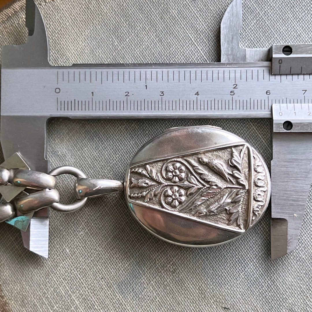 Detailed repoussé work on silver locket pendant