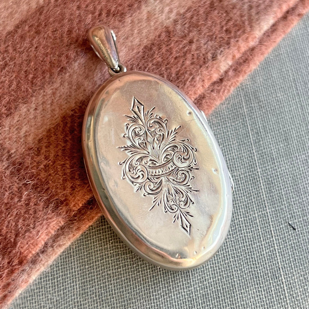 Close up antique floral engraving silver locket
