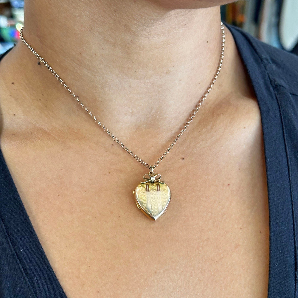 Victorian gold heart locket with engraved bow motif 